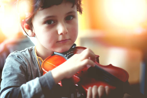 istock Child playing the violin in  room 1321126102