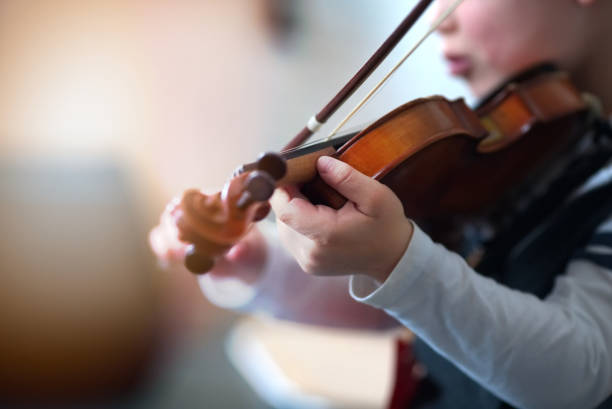 istock Child playing the violin in  room 1321126291