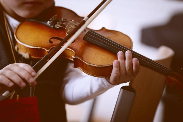 istock Child playing the violin in  room 1321126719