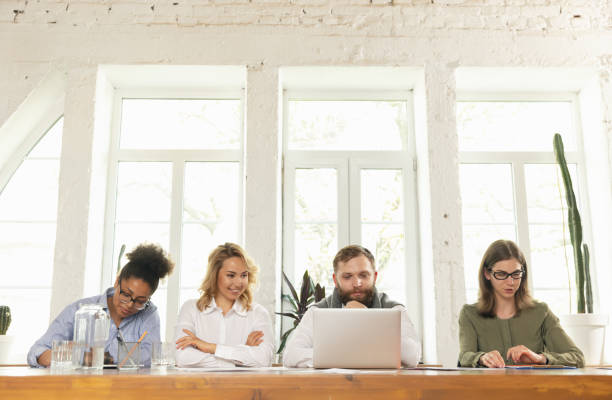 istock Young businessmen, colleagues working together in modern office using devices and gadgets during negotiations 1321127426