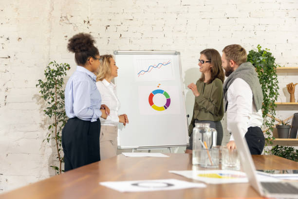 istock Group of young businessmen, colleagues working together in modern office using devices and gadgets 1321127525