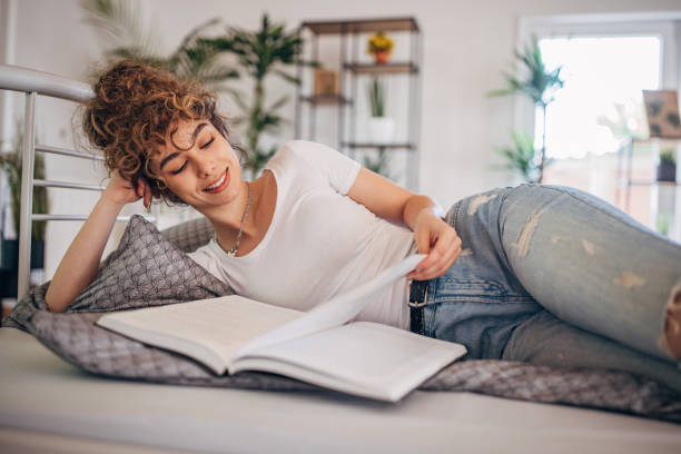 istock Beautiful woman reading in bed 1321132922