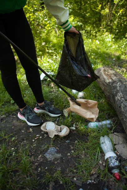 istock Volunteer picking trash in the forest 1321133150