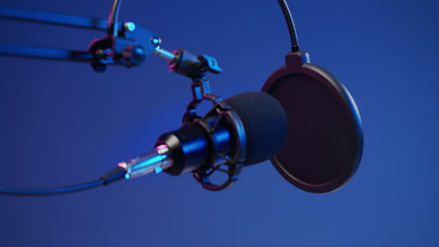 A close -up of a professional microphone against the blu background in a studio light