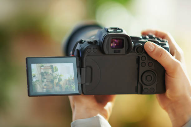 Closeup on modern woman at modern home in sunny day Interior videography. Closeup on modern woman with mirrorless camera at modern home in sunny day. modern cottage interior design stock pictures, royalty-free photos & images