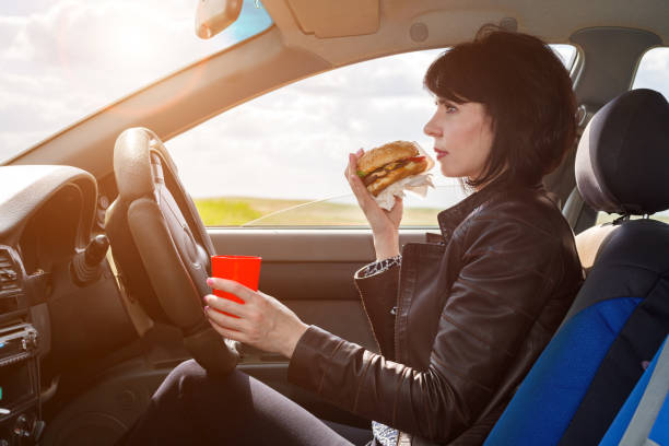 istock Businesswoman eats a burger on the way to work 1321138838