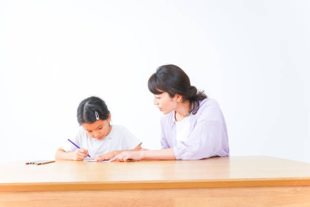 istock Girl studying with her mother at home 1321142251