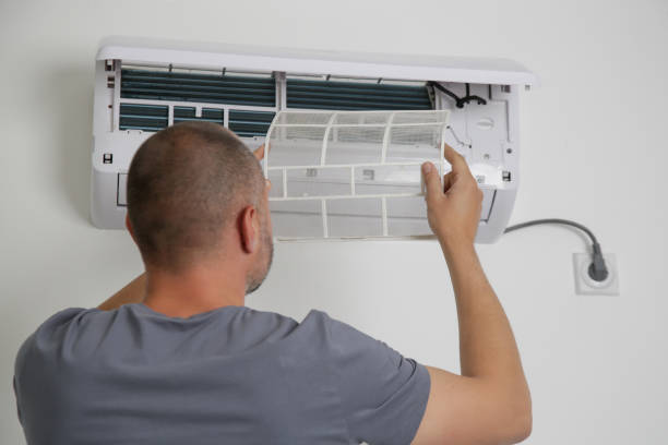 istock Man putting new clean air filter on air conditioner. 1321142918