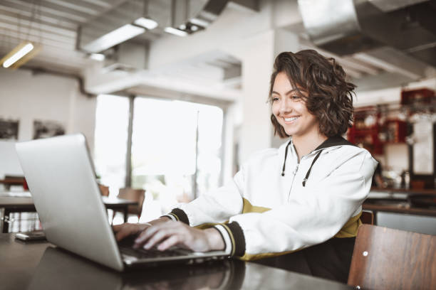 istock Cute Smiling Female Typing On Laptop While Relaxing In Coffee Bar 1321143236
