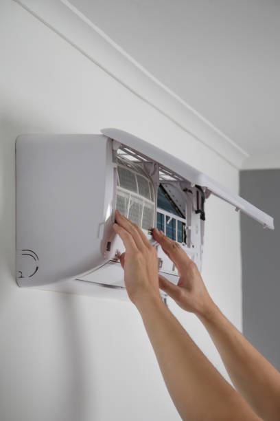 istock Man putting new clean air filter on air conditioner. 1321143241