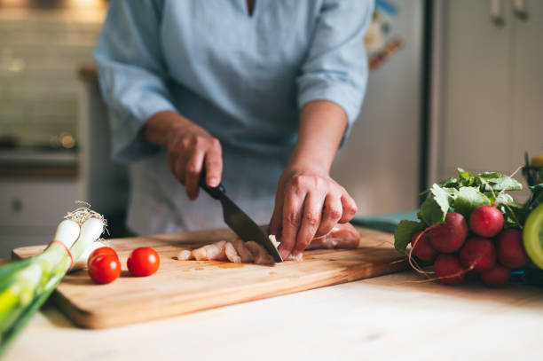 istock Woman cutting chicken meet 1321143251