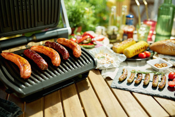 istock table with electric grill and grilled sausages 1321143367