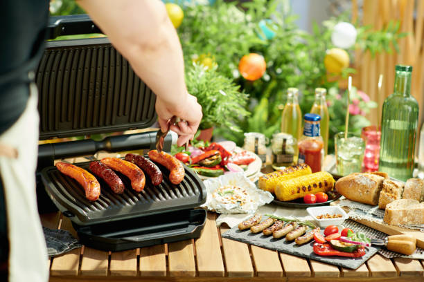 istock table with electric grill and grilled sausages 1321143400