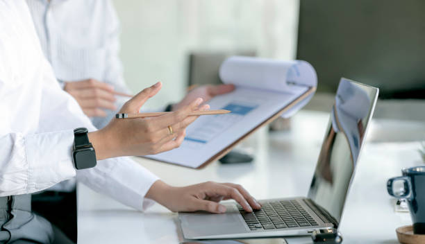 business planning work images Cropped shot of business people hands holding pencil and using laptop computer Cropped shot of business people hands holding pencil and using laptop computer while sitting at the table in office. business plan stock pictures, royalty-free photos & images