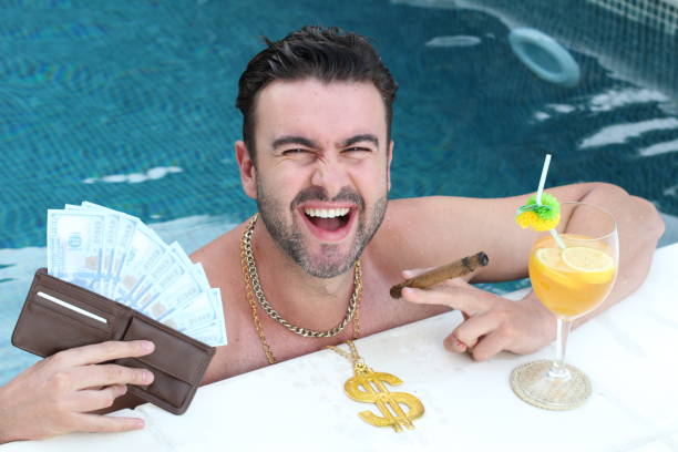 arroganter mann im schwimmbad mit geld, cocktail und zigarre - arroganz stock-fotos und bilder