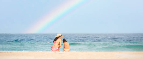 istock Mother and daughter playing on the rainbow beach 1321151538