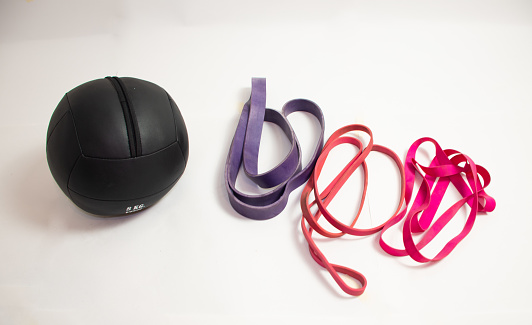medball with resistance bands in different resistances and colors on a white background