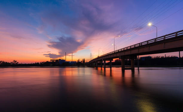 istock bridge over river in the evening. The light from the lamp to the reflector surface,Container Terminal in Hamburg, Germany. Bridge is called Koehlbrandbruecke - a bridge about the harbor. 1321155243