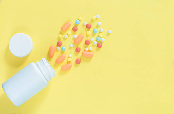 istock pills and pill bottles on yellow background,White pills and white bottle with copy space on yellow background, Healthy and Medicine concept. 1321155270