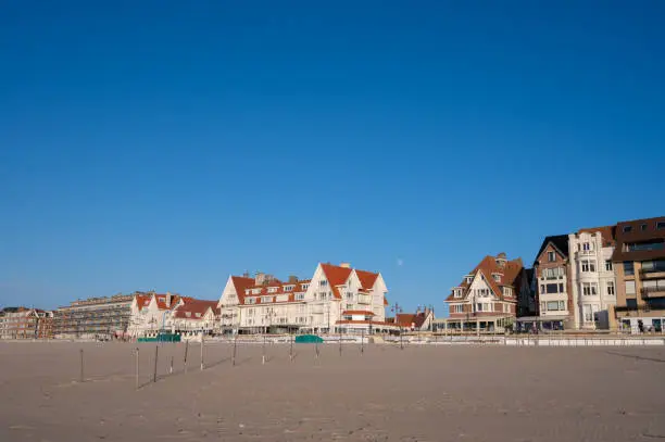 Yellow sandy beach in small Belgian town De Haan or Le Coq sur mer, luxury vacation destination, summer holidays on sunny day