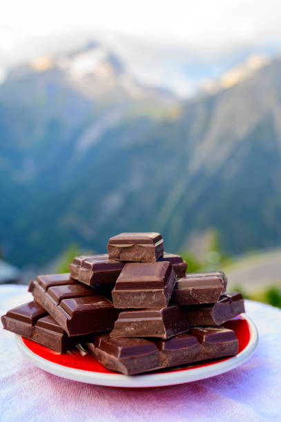 istock Handmade pure dark swiss chocolate and Alpine mountains on background 1321158761