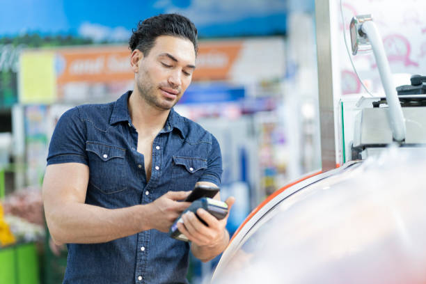istock Latino man pays grocery bill through electronic contact between cell phone and dataphone 1321160295
