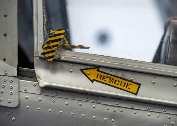 Silver coloured aeroplane jet rescue pilots canopy release with yellow arrow and text pointing to pull cord for emergency exit.
