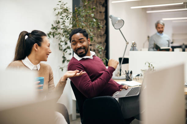 istock Happy business colleagues talking while working at corporate office. 1321165235