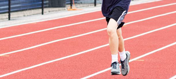 istock Legs of one runner on a red track 1321166225