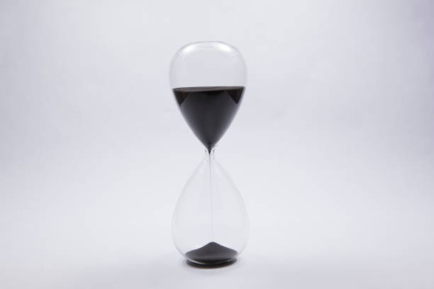 istock An hourglass with sand flowing on a white background. 1321166326
