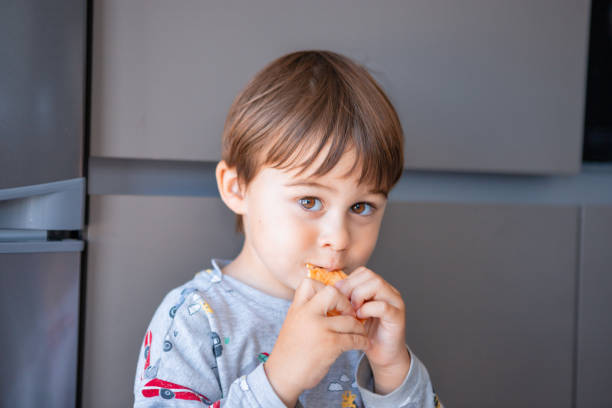 istock Little boy at home eating cookies 1321168471