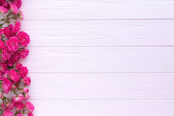istock Red roses on pink wooden background. Copy space, flat lay, 1321168750