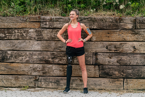 Young woman with prosthetic leg exercise outdoors