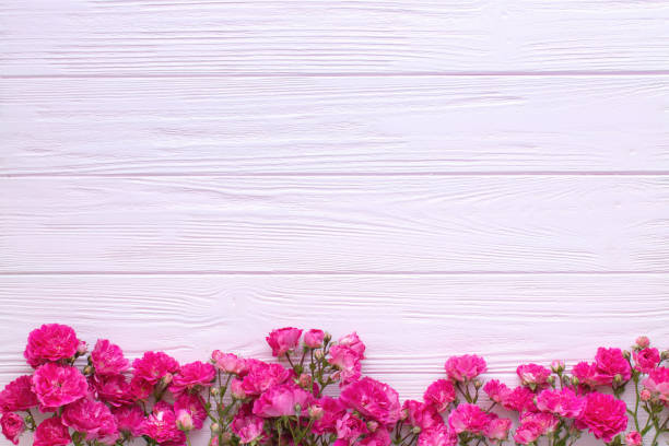 istock Red roses on pink wooden background. Copy space, flat lay, 1321168989