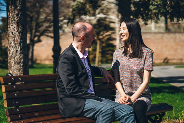 istock Multiethnic couple on a park bench 1321169048