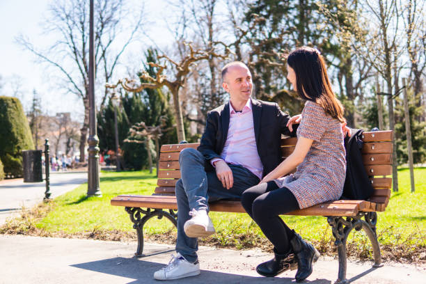 istock Multiethnic couple on a park bench 1321169599