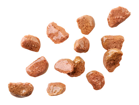 Cat food pieces of meat are flying on a white background isolated