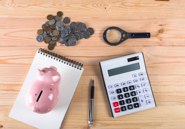 istock piggy bank, calculator and coins 1321169920