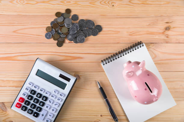 istock piggy bank, calculator and coins 1321169934