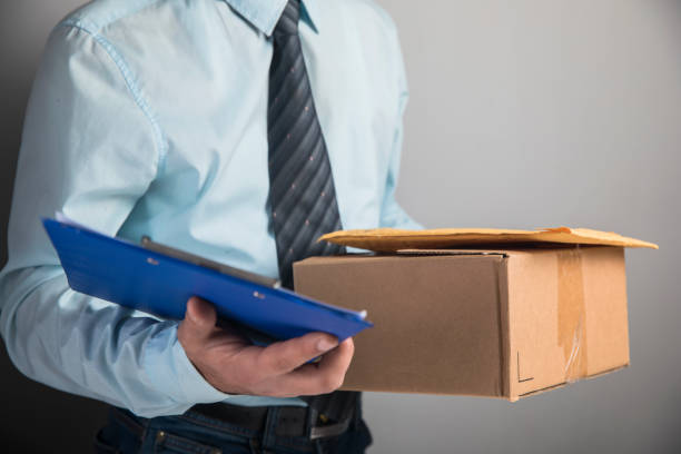 istock the courier holds the parcel and papers 1321170073