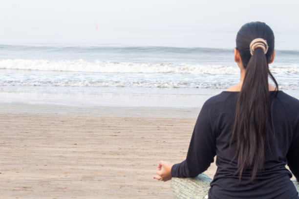 istock Back of woman practicing yoga at the beach 1321170355