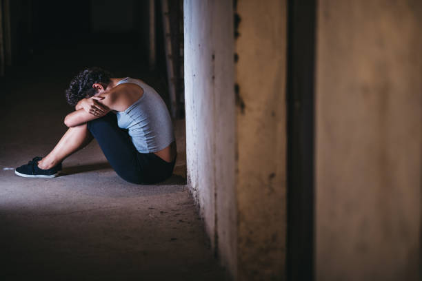 mujer indefensa deprimida sentada sola - drug abuse addiction women violence fotografías e imágenes de stock