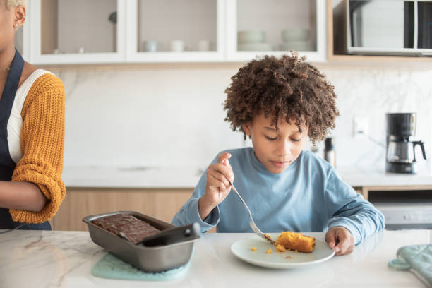 istock Siblings eating cake in the kitchen. 1321173520
