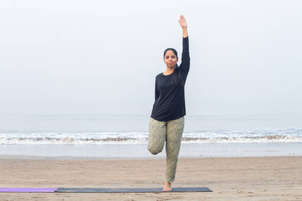 istock Woman practicing yoga at the beach 1321173696