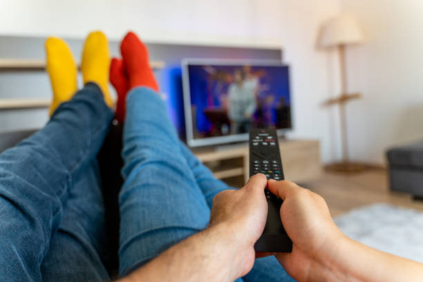 istock Young couple changing channels while relaxing on sofa at home. 1321174009