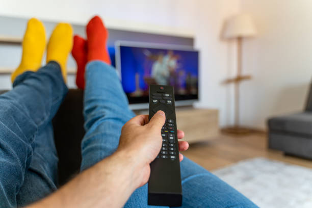 istock Young couple changing channels while relaxing on sofa at home. 1321174010