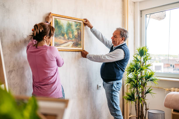 istock Senior couple hanging picture on wall 1321174122