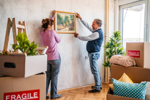 istock Senior couple hanging picture on wall 1321174169