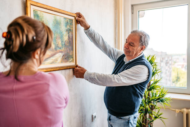 istock Senior couple hanging picture on wall 1321174198