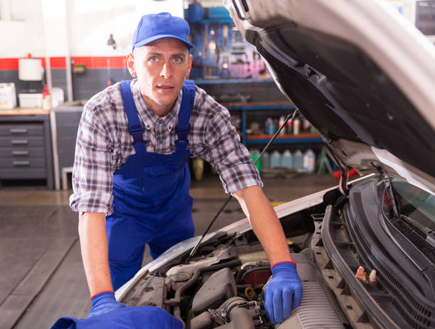 istock Car mechanic looking at open car hood for internal checking 1321175290